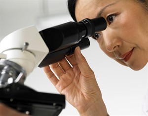woman looking into microscope