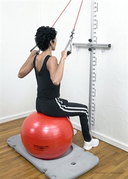 woman on exercise ball with resistance bands