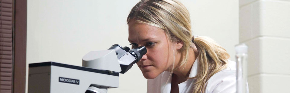 student looking in microscope