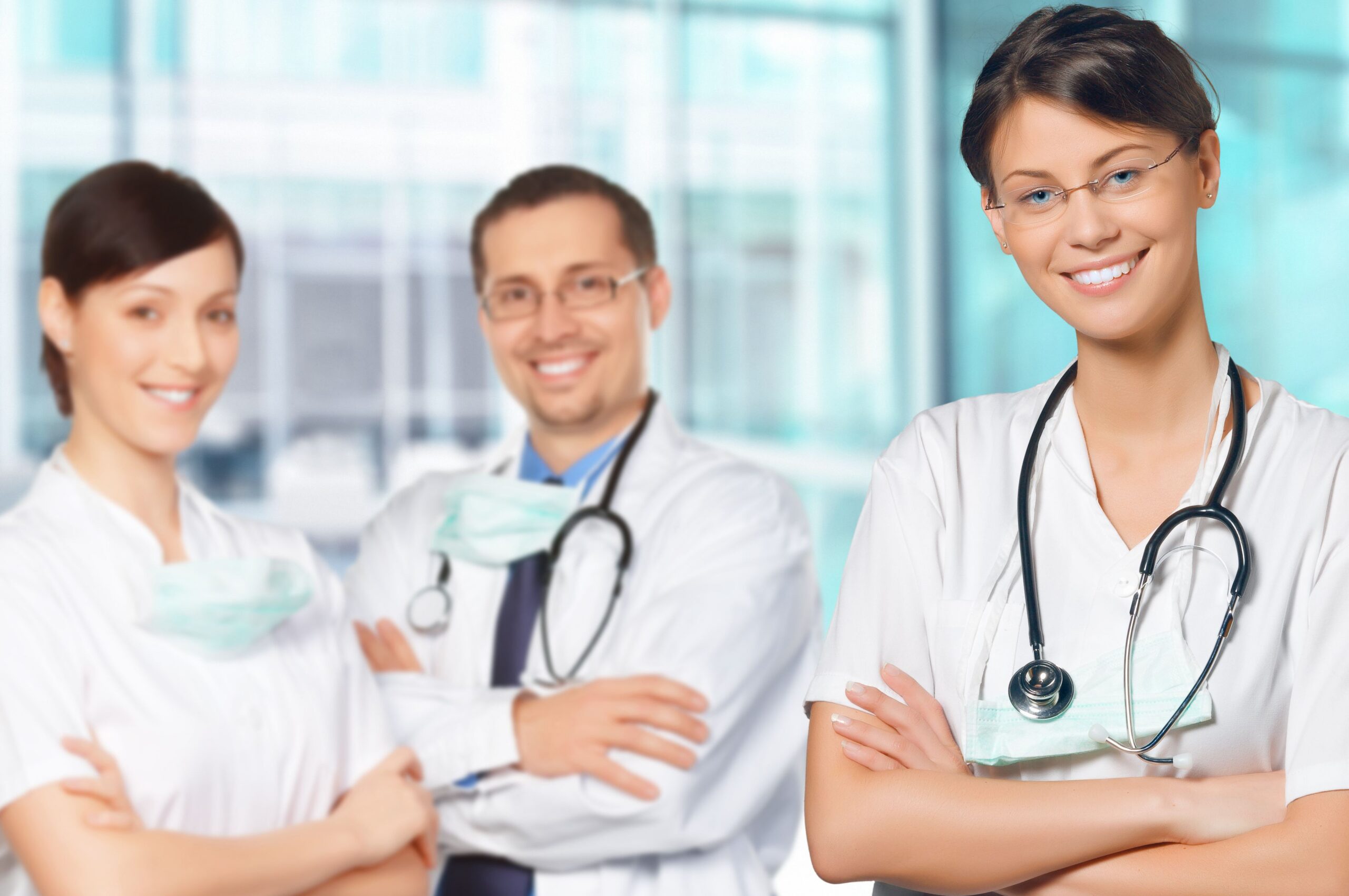 3 smiling interns in white medical coats