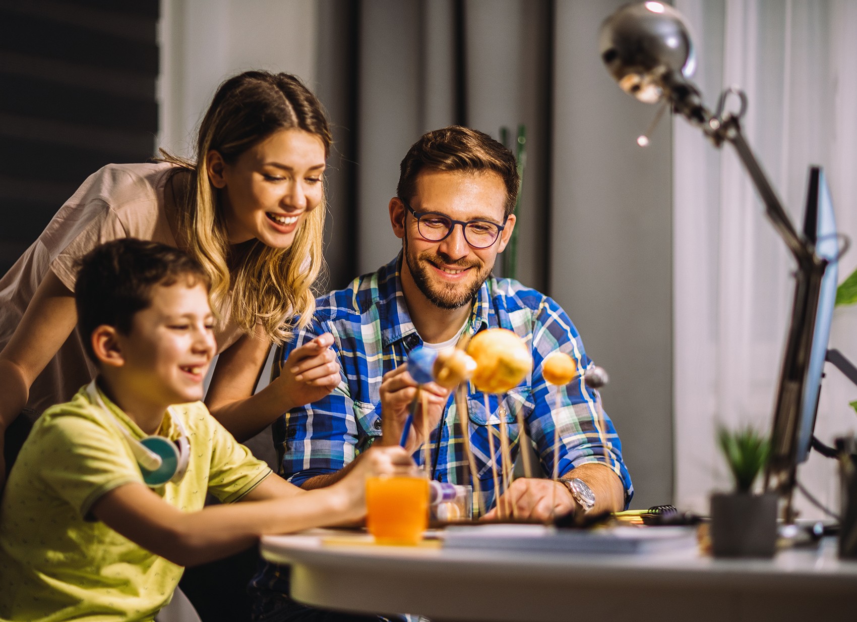 Family working on school project at the dining table.