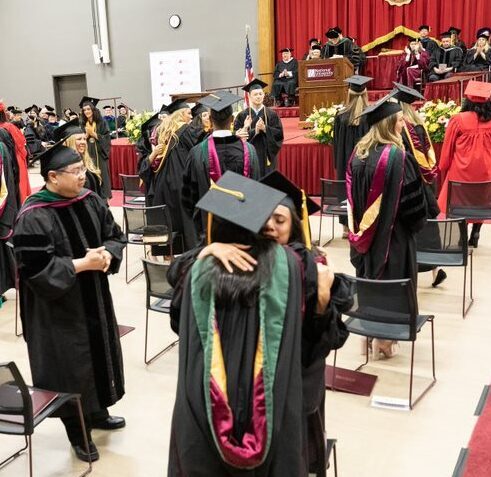 graduates hugging at commencement
