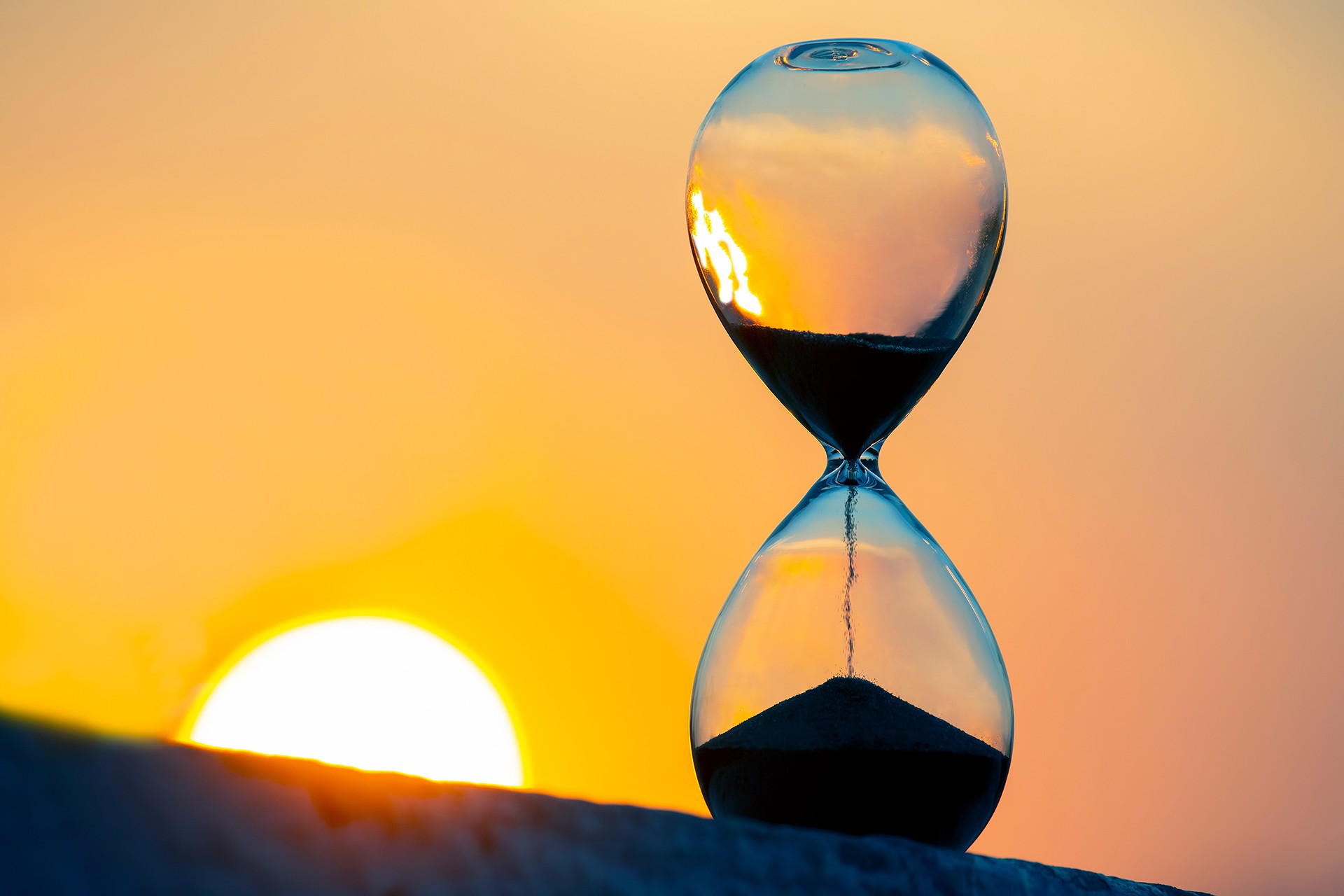 Hourglass with the background of a sunset