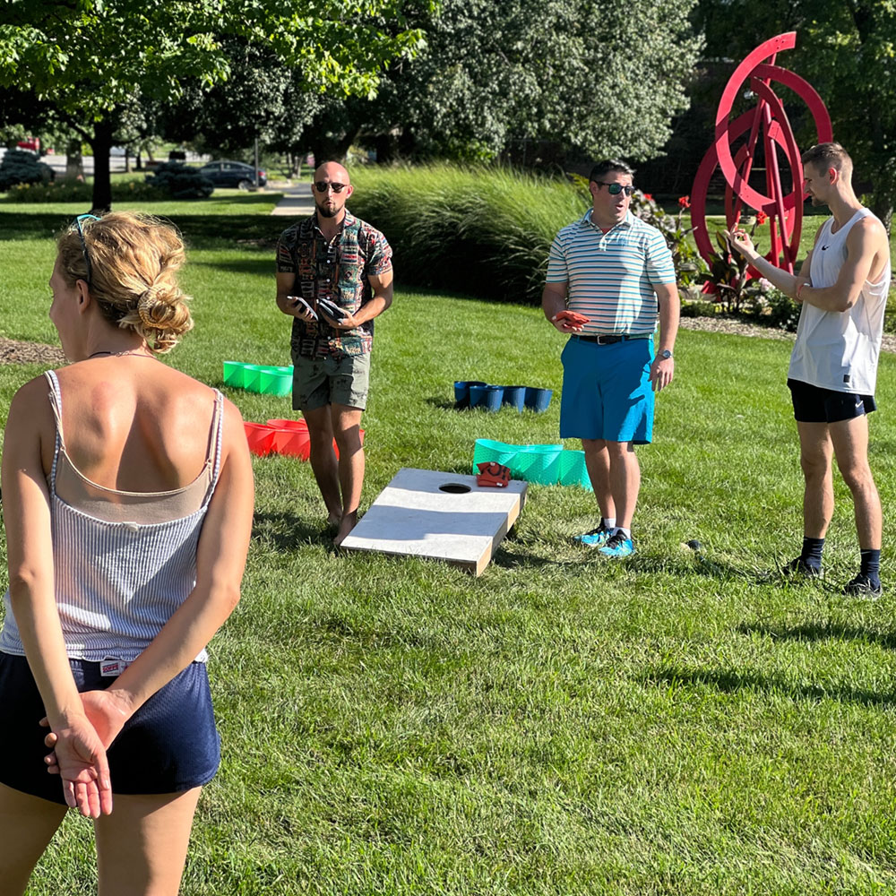 students playing cornhole on lawn