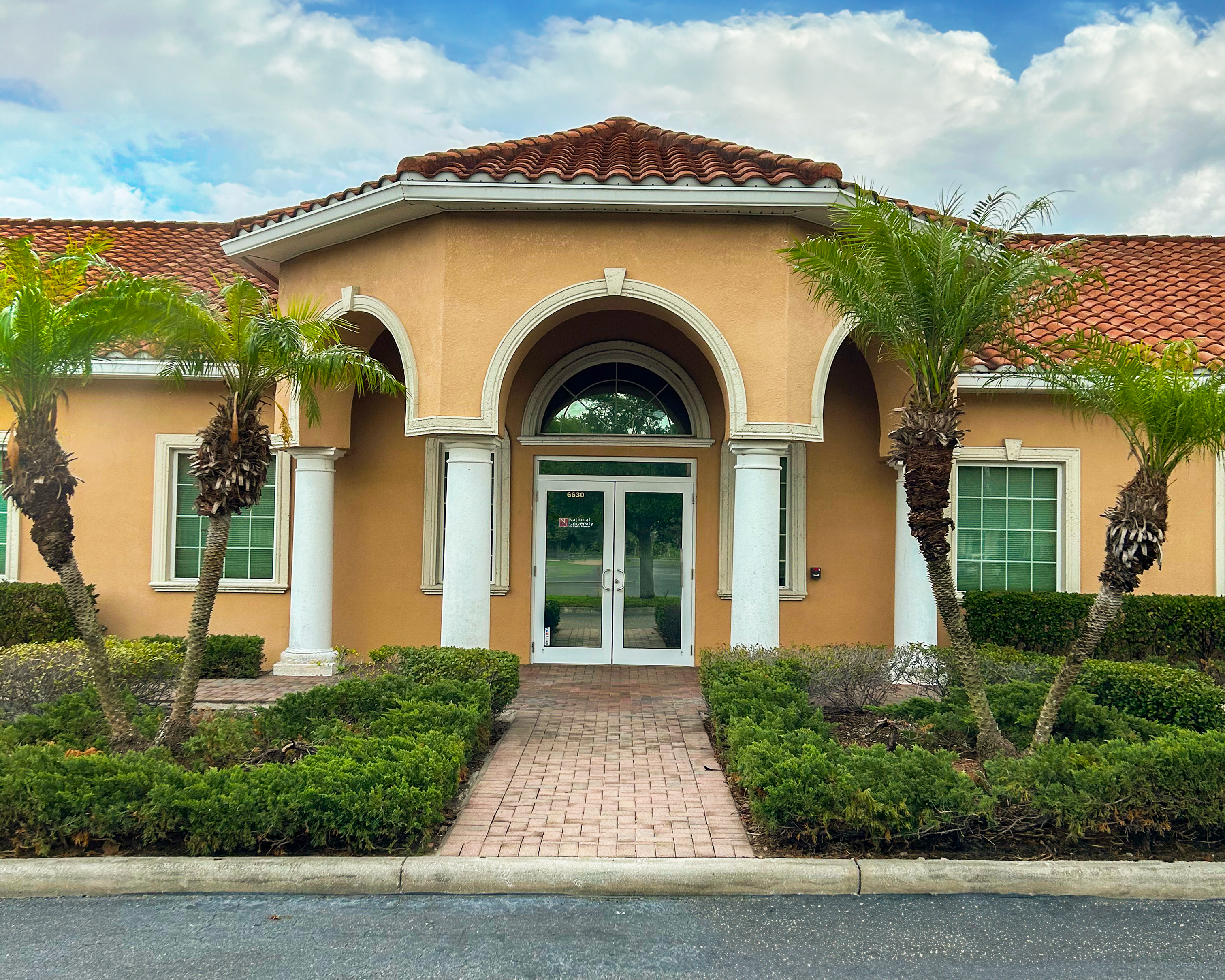 Office building in Florida with palm trees and other greenery in front