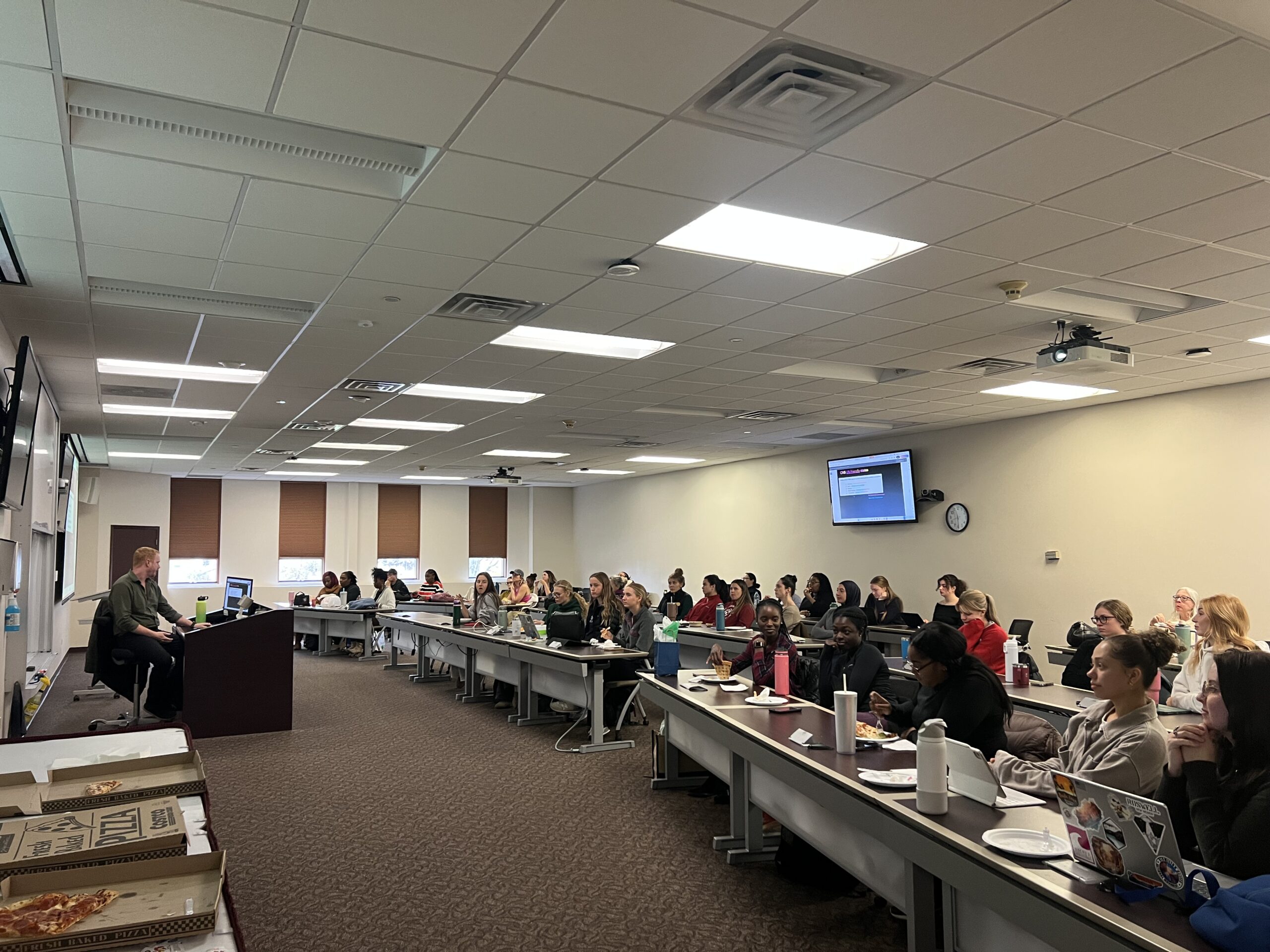 Dr. Robinson presents in front of a full classroom of students