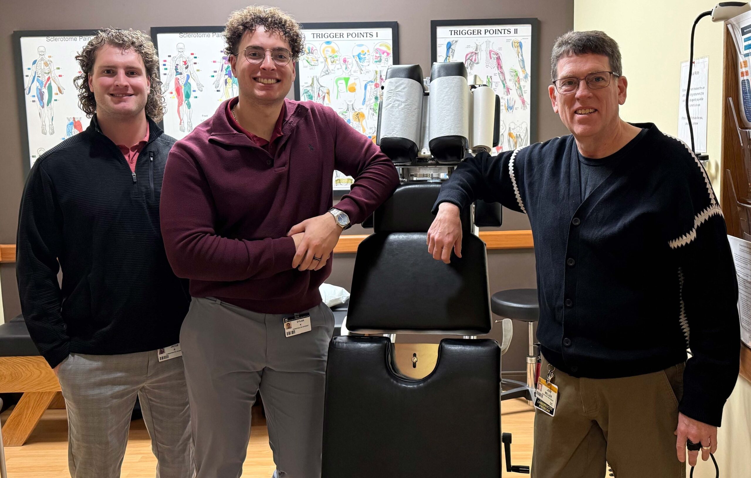 Two male NUHS chiropractic students with their instructor in a classroom setting