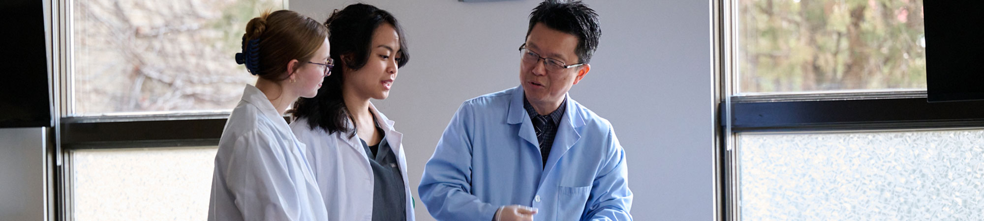 instructor with two students in anatomy lab