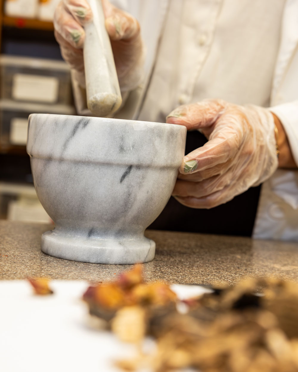 student working with herbs in dispensary