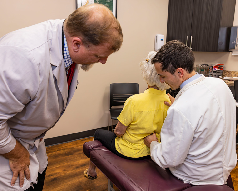 DC clinician and student working with patient in clinic