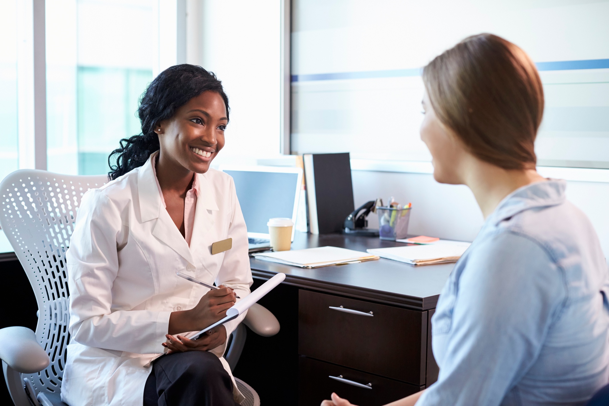 Female patient sitting with doctor in office