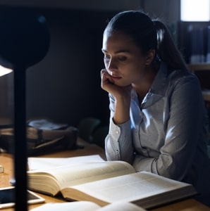 female student studying over books