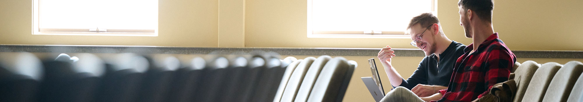 two students working in an empty lecture hall