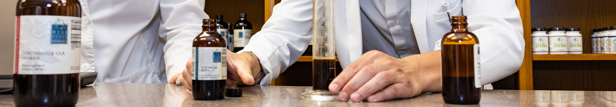 faculty and student working with liquid medicines in dispensary