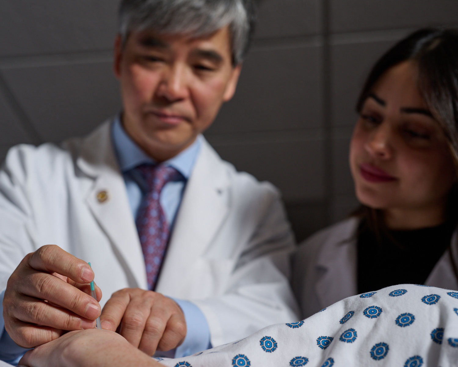 student watching instructor work on acunpuncture client
