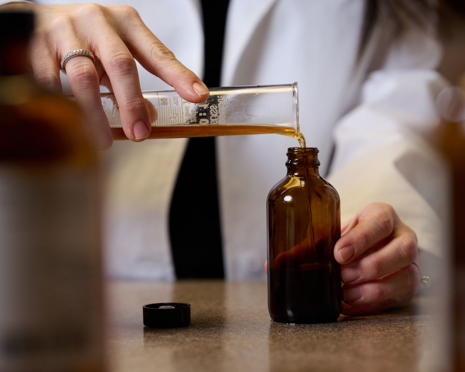 nd student pouring tincture in dispensary