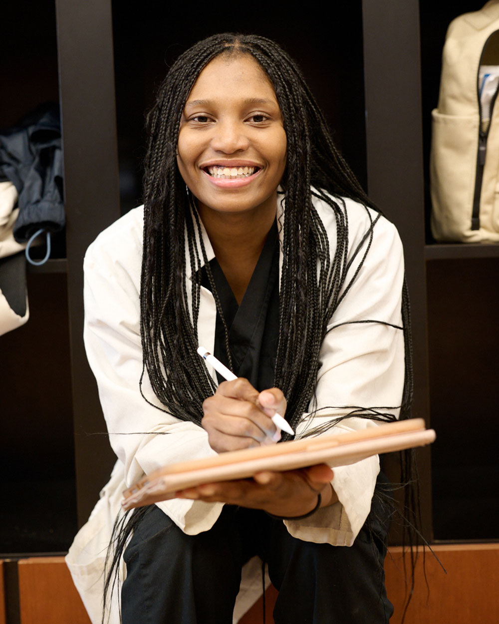 student holding tablet and smiling