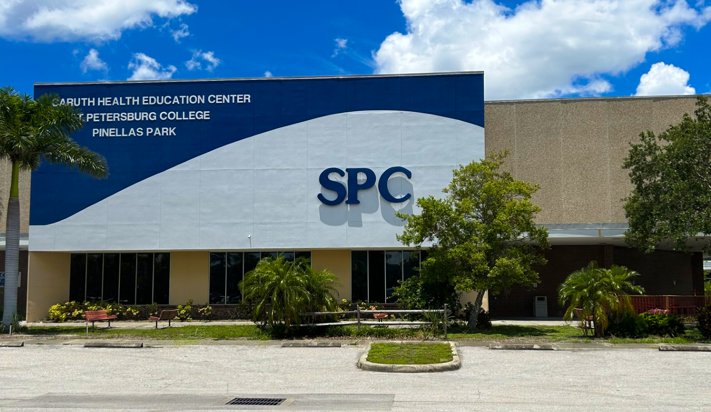 An office building with "SPC" written on the front. Trees and other scrubs surround the front of the building